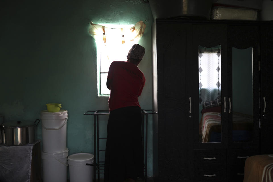 Matefo Litali opens the curtains of her small rented room that she shares with her youngest daughter and a granddaughter, in the town of Ha Thetsane, Maseru, Lesotho, on Friday, Dec. 11, 2020. While she waited for her final paycheck after being laid off, Litali received no income or support for three months. The family survived off food parcels donated by the local church until her salary arrived. “I got so stressed I thought I was going mad,” she explains. “I would spend the whole day in my house sleeping, not doing anything. It got to a stage where I wouldn’t even try to talk with my daughter. She would ask me: ‘Are you sick? What is the problem?’ and I wouldn’t say anything to her. I didn’t want to speak to anyone or ask for help.” (Neo Ntsoma/The Fuller Project via AP)