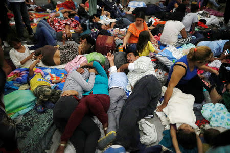 Honduran migrants, part of a caravan trying to reach the U.S., rest inside an improvised shelter during a new leg of their travel in Chiquimula, Guatemala October 16, 2018. REUTERS/Edgard Garrido