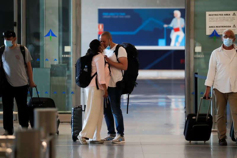 Tourist couple kiss as they arrive at Malaga-Costa del Sol Airport, in Malaga