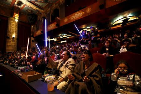 Moviegoers cheer and wave lightsabers before the first showing of the movie "Star Wars: The Force Awakens" at the TCL Chinese Theatre in Hollywood, California, December 17, 2015. REUTERS/Mario Anzuoni
