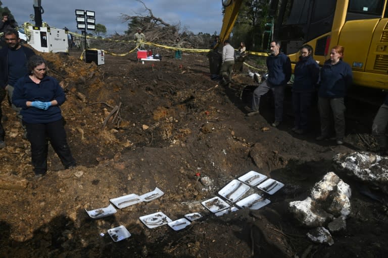 La antropóloga forense Alicia Lusiardo observa restos humanos hallados en una excavación en busca de personas detenidas y desaparecidas durante la dictadura de Uruguay, en un predio militar en Toledo, departamento de Canelones, el 7 de junio de 2023 (Pablo PORCIUNCULA)