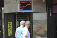 People walk past the Waikiki Gun Club, Thursday, June, 23, 2022 in Honolulu. In a major expansion of gun rights after a series of mass shootings, the Supreme Court said Thursday that Americans have a right to carry firearms in public for self-defense.