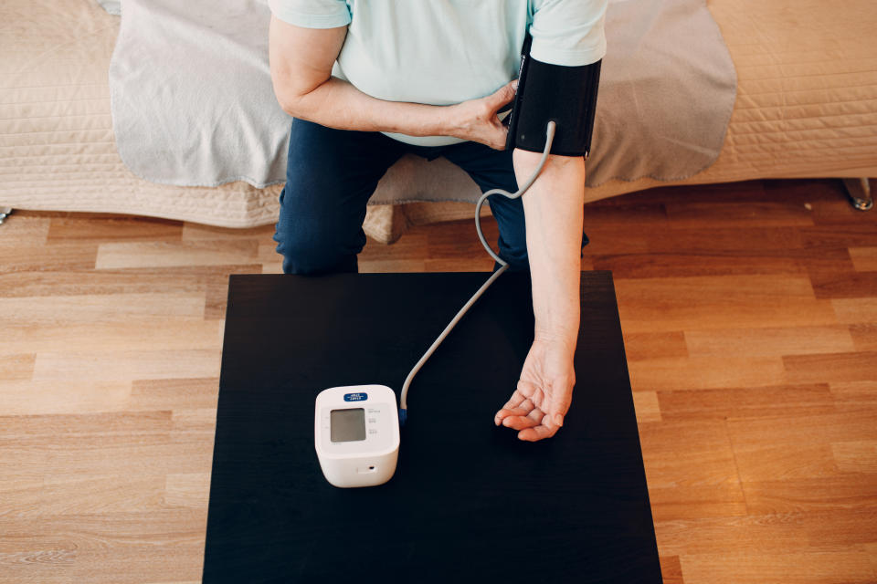 Senior woman taking measures blood pressure at home to prevent stroke. (Getty Images)