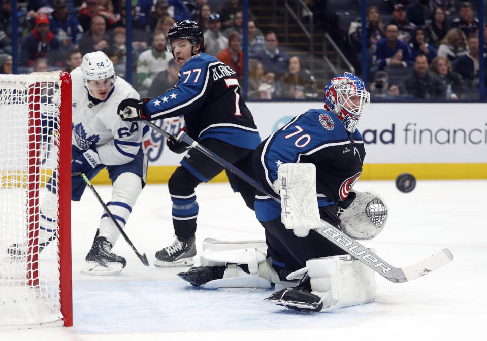 Columbus Blue Jackets goalie Joonas Korpisalo, right, makes a stop in front of Toronto Maple Leafs forward David Kampf, left, and Blue Jackets defenseman Nick Blankenburg during the first period of an NHL hockey game in Columbus, Ohio, Friday, Feb. 10, 2023. (AP Photo/Paul Vernon)