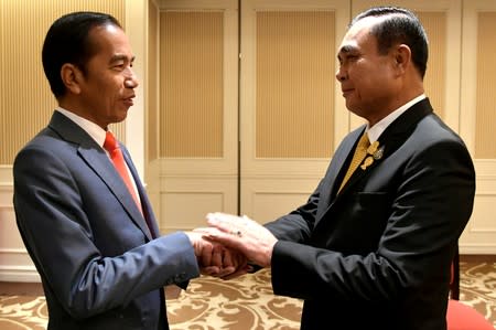 Indonesian President Joko Widodo shakes hands with Thailand's Prime Minister Prayuth Chan-ocha during their bilateral meeting in Bangkok