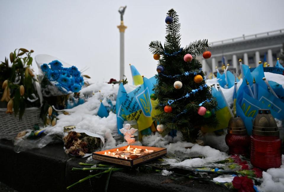 Ukrainian flags with the names of fallen soldiers are visible in Independence Square in Kyiv in December 2023. <a href="https://www.gettyimages.com/detail/news-photo/flowers-candles-and-a-small-christmas-tree-near-ukrainian-news-photo/1841160234?adppopup=true" rel="nofollow noopener" target="_blank" data-ylk="slk:Sergei Chuzavkov/SOPA Images/LightRocket via Getty Images;elm:context_link;itc:0;sec:content-canvas" class="link ">Sergei Chuzavkov/SOPA Images/LightRocket via Getty Images</a>