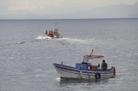 A boat, top, carrying a dive team passes a fishing boat as it heads out to the site of the Bayesian on the fourth day of the search and recovery operation after the luxury yacht sank in a storm on Monday whilst moored around half a mile off the coast of Porticello, Sicily. ( Jonathan Brady/PA via AP)