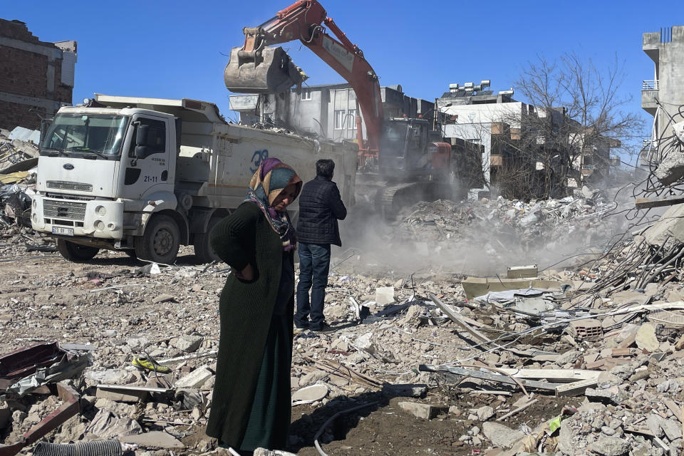 Parents of Taha Erdem, mother Zeliha Erdem, left, and father Ali Erdem stand next to the debris from the building where Tahan was trapped after the earthquake of Feb. 6, in Adiyaman, Turkey, Friday, Feb. 17, 2023. Taha Erdem, a resident of southeastern Turkey's Adiyaman, is one of the hundreds of survivors pulled out of collapsed buildings after the Feb. 6 powerful quake. Erdem, who is 17, filmed himself on his phone while stuck and sandwiched between concrete in what he thought would be his last words. (AP Photo/Mehmet Mucahit Ceylan)