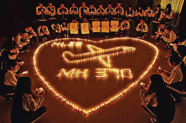 浙江一間國際學校的中外師生，昨點起蠟燭為馬航機上乘客祈福。（新華社）