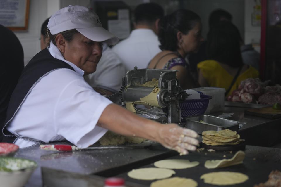 Una empleada lanza una tortilla a la plancha en la taquería Tacos El Califa de León en Ciudad de México, el miércoles 15 de mayo de 2024. Tacos El Califa de León es la primera taquería en recibir una estrella Michelin. (AP Foto/Fernando Llano)