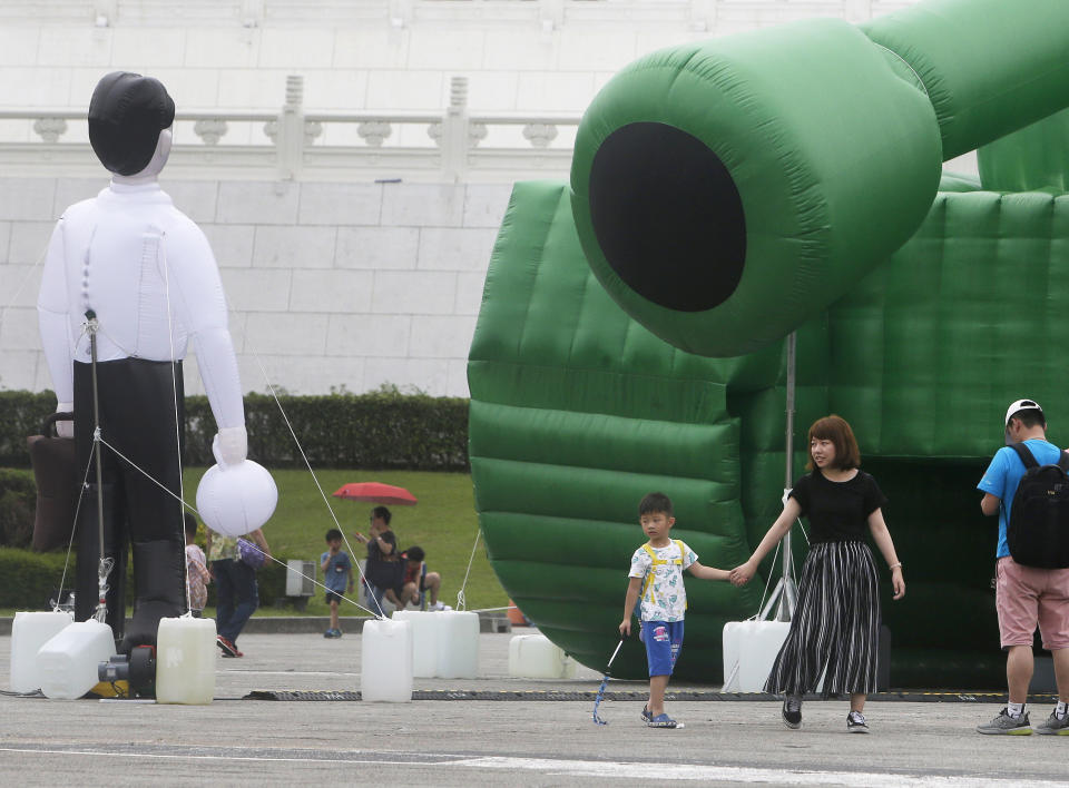 Tourists walk past an inflatable tank man at the Liberty Square of Chiang Kai-shek Memorial Hall in Taipei, Taiwan, Saturday, June 1, 2019. An artist erected the inflatable display in Taiwan’s capital to mark an iconic moment in the Tiananmen Square pro-democracy protests. The larger-than-life balloon installation, which stands in front of Taipei’s famous hall, portrays a peaceful encounter between a Chinese civilian and the military tanks that contributed to a brutal shutdown of the demonstrations in Beijing on June 4, 1989. (AP Photo/Chiang Ying-ying)