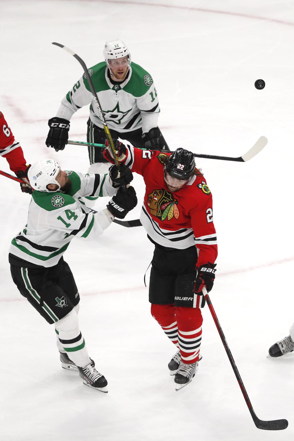 Dallas Stars left wing Jamie Benn (14) and Chicago Blackhawks center Ryan Carpenter (22) battle for the puck during the second period of an NHL hockey game Tuesday, April 6, 2021, in Chicago. (AP Photo/Jeff Haynes)