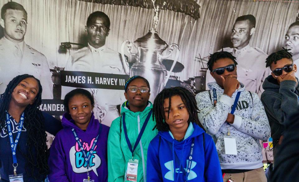 A group of students from Washington Irving Neighborhood School in Indianapolis pose Friday, Oct. 27, 2023, in front of a poster which shows the single photograph taken of the pilots in the 332nd Fighter Group, better known as the Tuskegee Airmen, after their win at the first-ever United Sates Air Force Aerial Gunnery Competition in 1949. "They were the first Top Guns," Reginald DuValle, president of the Indianapolis Chapter of Tuskegee Airmen, Inc., said. "What would we as a society be like if we all knew that the first top guns were Black?"