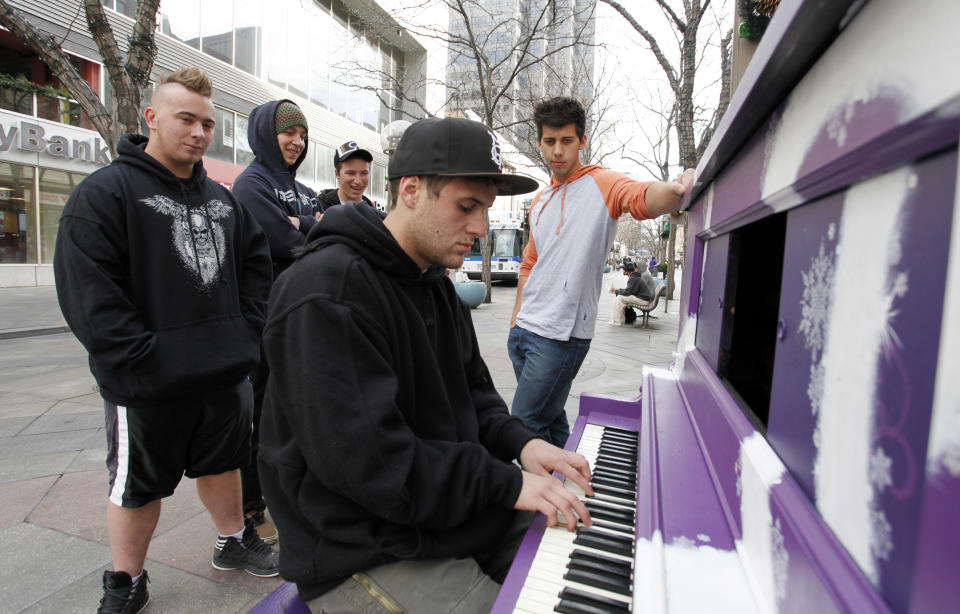 This photo taken on Dec. 7, 2012 shows Justin Niederhauser, 19, from Boise, Idaho, as he plays the piano on the 16th Street Mall in downtown Denver. A ride through downtown's 16th Street Mall on the free bus shuttle is a ride through Denver's past and current scene. (AP Photo/Ed Andrieski)