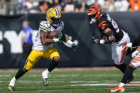 Green Bay Packers running back Aaron Jones (33) cuts away from Cincinnati Bengals defensive end Sam Hubbard (94) in the first half of an NFL football game in Cincinnati, Sunday, Oct. 10, 2021. (AP Photo/AJ Mast)