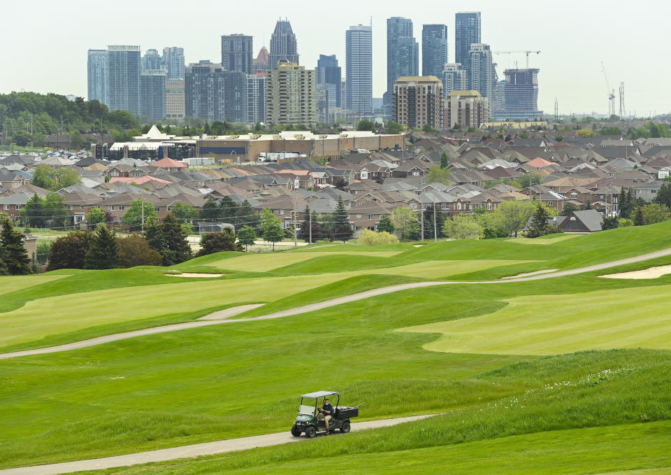 A maintenance worker prepares the final finishing touches at BraeBen Golf Course as all golf courses are set to open Saturday in Mississauga, Ontario, Friday, May 21, 2021. (Nathan Denette/The Canadian Press via AP)