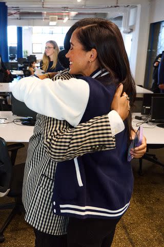 <p>Lee Morgan for The Archewell Foundation</p> Meghan Markle shares a hug during a visit at The Marcy Lab School In Brooklyn, New York.