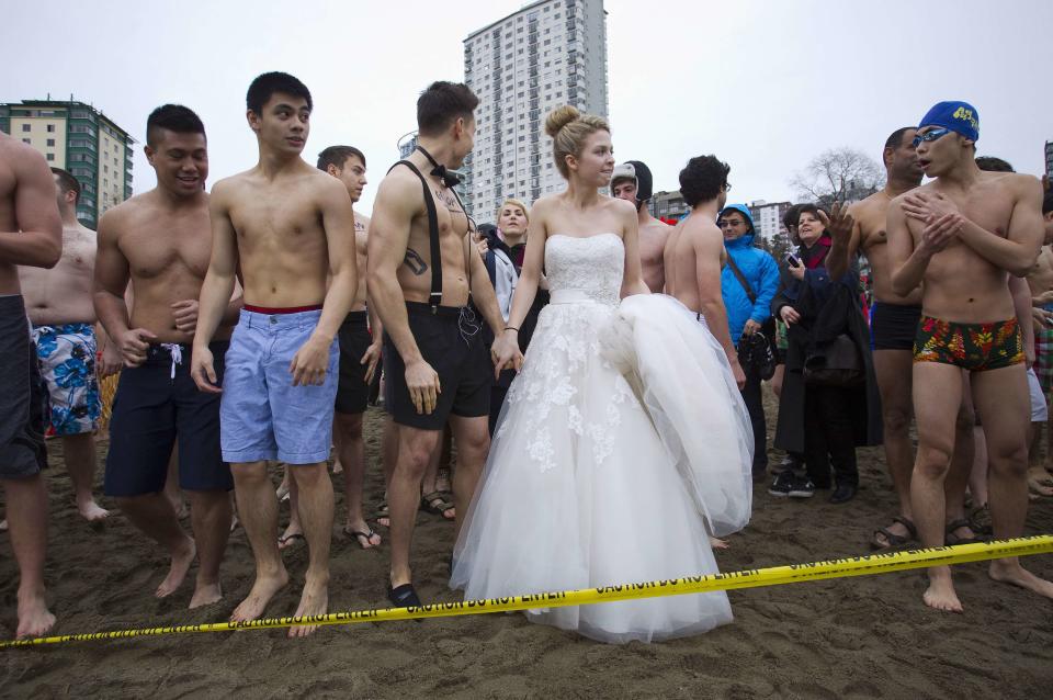 A woman wearing a wedding dress prepares to run into English Bay during the 94th annual New Year's Day Polar Bear Swim in Vancouver.