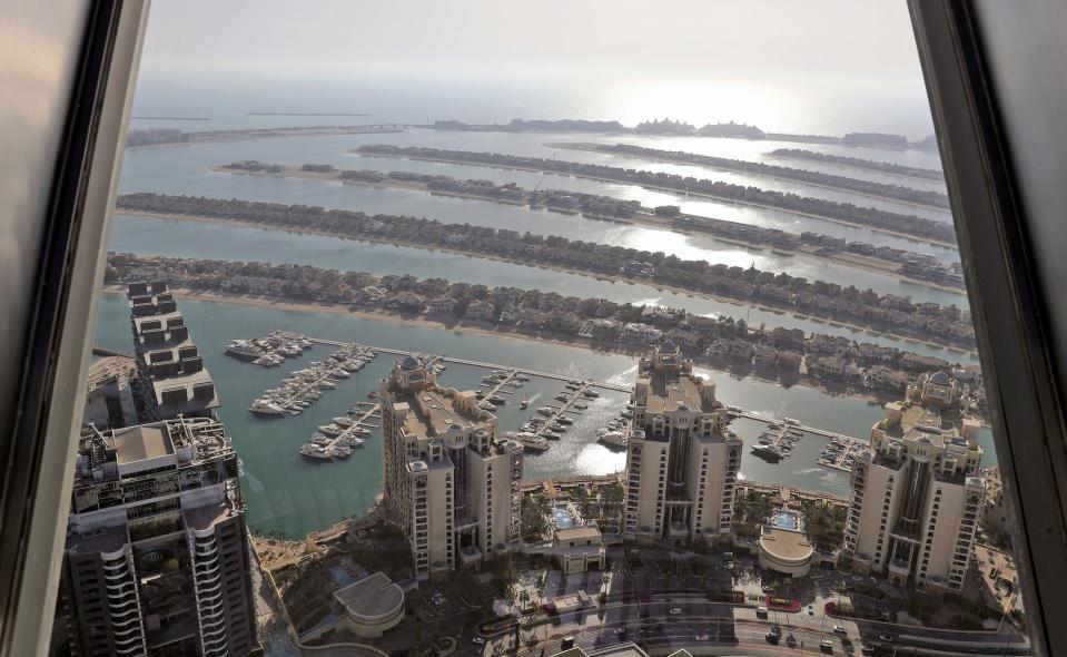 A portion of the Palm Jumeirah Island's frond villas and residential towers are seen from an observation deck of The View at The Palm Jumeirah, in Dubai, United Arab Emirates, Tuesday, April 6, 2021. Foreign buyers flush with cash have flooded the high-end property market in Dubai even as coronavirus vaccines roll out unevenly across the world and waves of infections force countries to extend restrictions. It's one of the few places in the world where they can dine, shop and do business in person. (AP Photo/Kamran Jebreili)