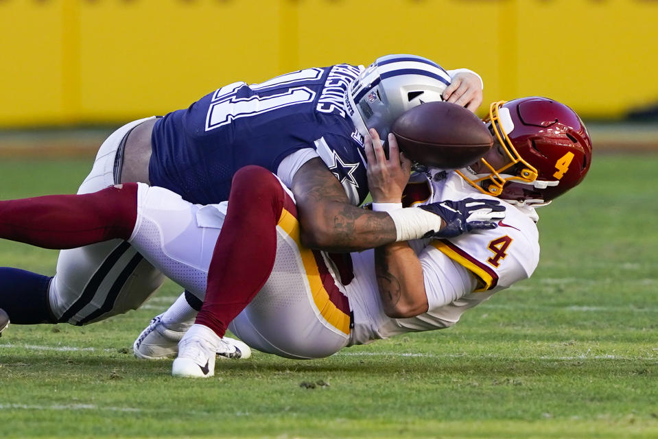 Washington Football Team quarterback Taylor Heinicke (4) fumbles the ball as he is sacked by Dallas Cowboys outside linebacker Micah Parsons (11) during the first half of an NFL football game, Sunday, Dec. 12, 2021, in Landover, Md. Dallas recovered the ball and scored a touchdown on this play. (AP Photo/Alex Brandon)