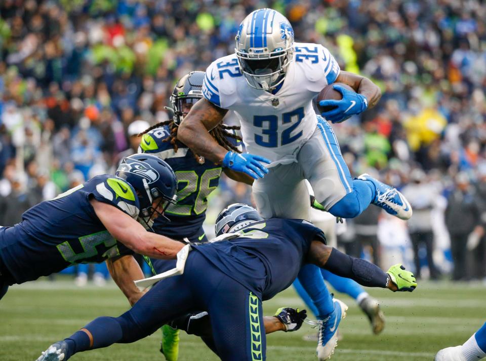 Detroit Lions running back D'Andre Swift is tackled by the Seattle Seahawks defense during the third quarter at Lumen Field in Seattle, Jan. 2, 2022.