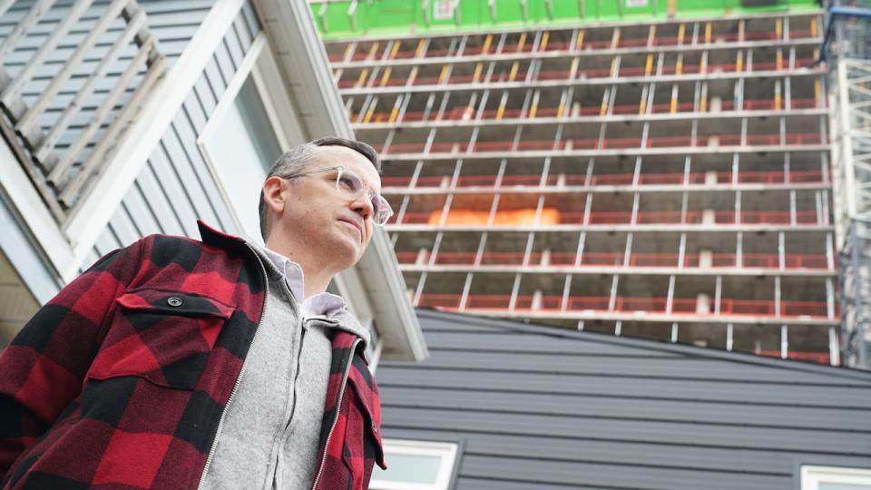 Ken MacInnes stands on his front deck as the new high-rise at 2070 Scott Street looms over him.  