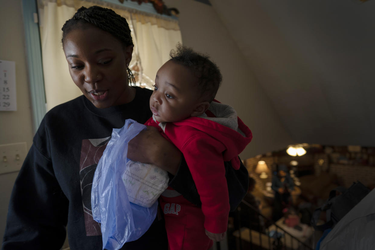 Ansonia Lyons carries her son, Adrien Lyons, as she takes him for a diaper change in Birmingham, Ala. (AP Photo/Wong Maye-E)