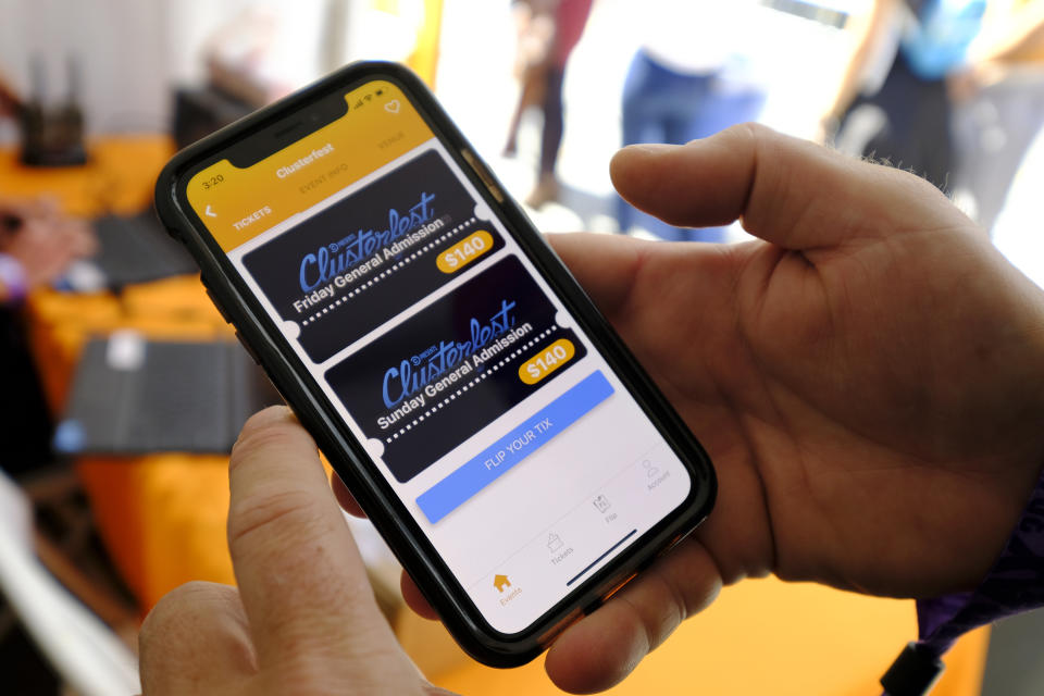In this photo taken Friday, June 21, 2019, FlipTix CEO Jaime Siegel demonstrates his company's application at the Clusterfest comedy event in San Francisco. The company's application lets people who leave a venue early sell their ticket and lets someone who wants the remainder of the ticket buy it. (AP Photo/Eric Risberg)