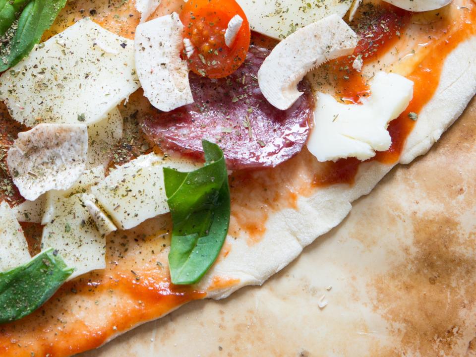 Heart-shaped pizza on dough board