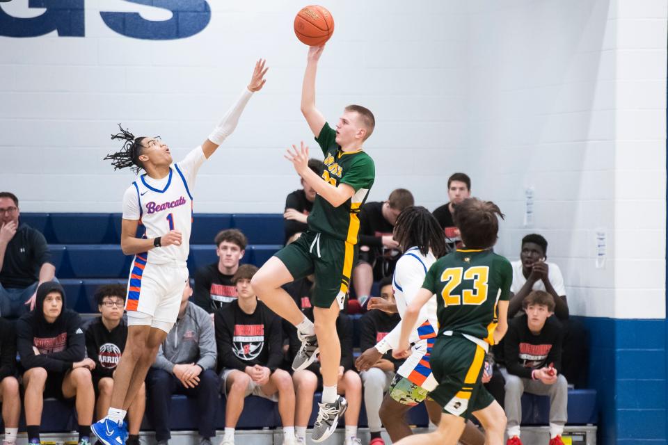 York Catholic's Jake Dallas hits a teardrop shot over York High's Daveyon Lydner (1) during a YAIAA boys' quarterfinal game at West York Area High School on Friday, February 10, 2023. The Bearcats won, 68-49.