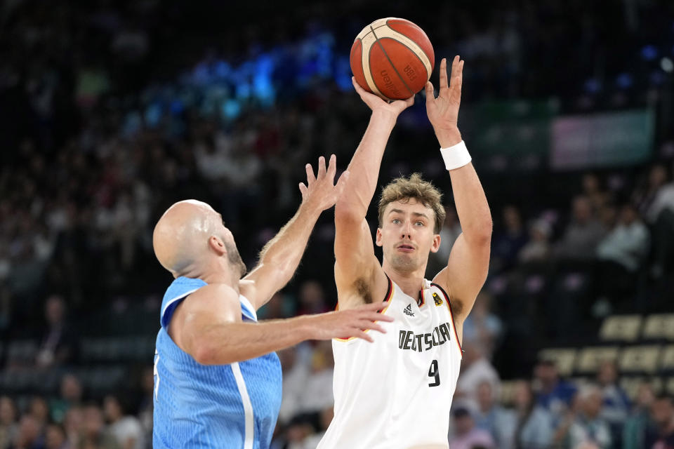 El alemán Franz Wagner dispara al aro frent al griego Nick Calathes en los cuartos de final del baloncesto masculino de los Juegos Olímpicos de París, el martes 6 de agosto de 2024. (AP Foto/Michael Conroy)