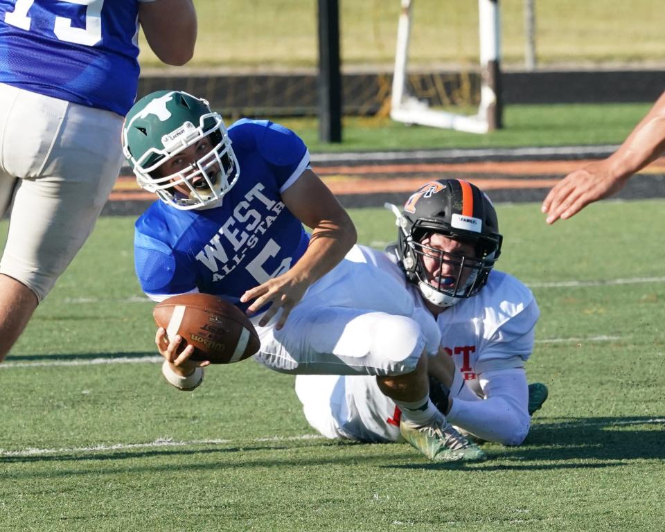 Tecumseh's Craig Kole of the East All-Stars sacks Sand Creek quarterback George Hillard of the West during Friday's Lenawee County Football Senior Showcase at Tecumseh.