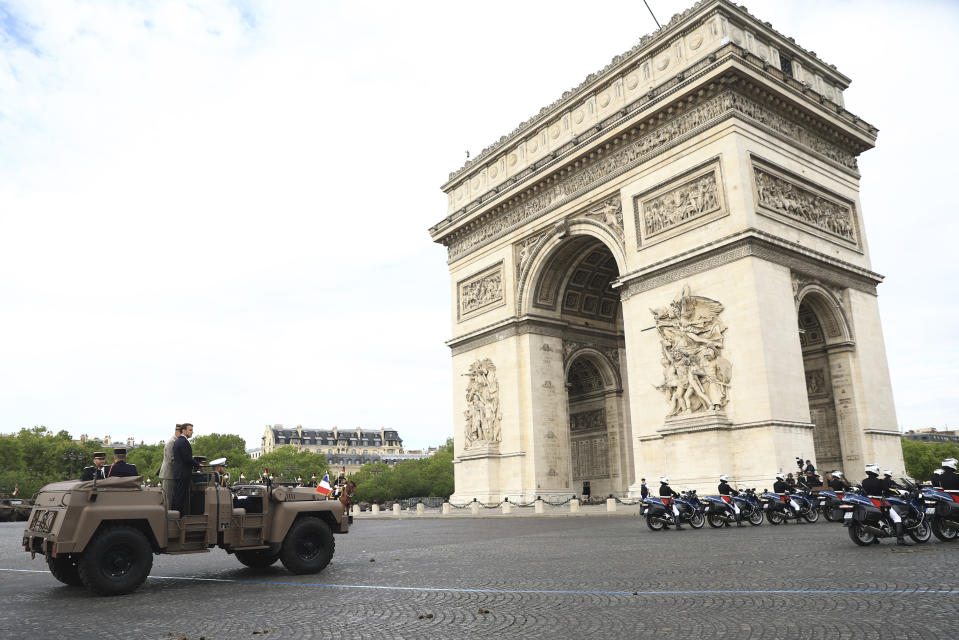 French President Emmanuel Macron stands in the command car at the Arc de Triomphe during the Bastille Day military parade Friday, July 14, 2023 in Paris. France is celebrating its national holiday with whizzing warplanes and a grand Bastille Day parade in Paris. (AP Photo/Aurelien Morissard, Pool)
