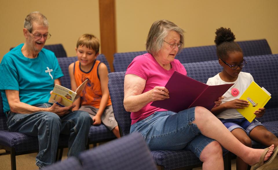 Volunteers work with children in a Bookworm reading session recently during Project Transformation summer literacy day camp at New Hope United Methodist Church, 11600 N Council.