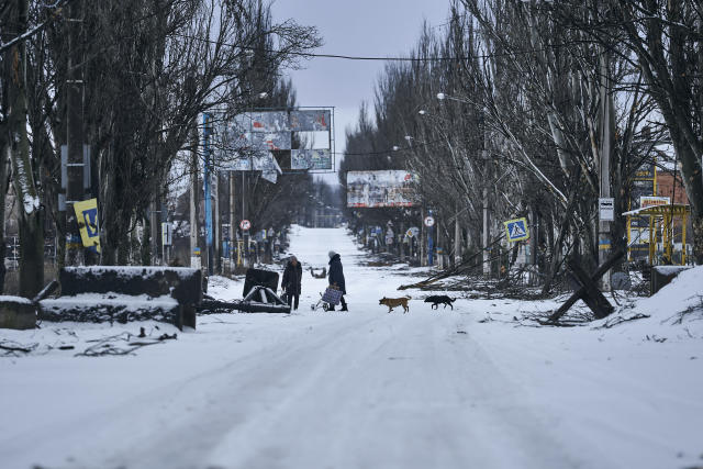 FILE - Local residents walk along a street in Bakhmut, Donetsk region, Ukraine, Tuesday, Feb. 14, 2023. The relentless Russian bombardment has reduced Bakhmut to smoldering wasteland with few buildings still standing intact as Russian and Ukrainian soldiers have fought ferocious house-to-house battles amid the ruins. (AP Photo/Libkos, File)