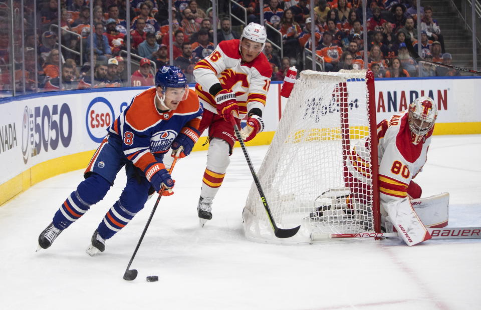 Calgary Flames Nikita Zadorov (16) chases Edmonton Oilers' Zach Hyman (18) as goalie Dan Vladar (80) looks for the puck during the second period of an NHL hockey game Saturday, Oct. 15, 2022, in Edmonton, Alberta. (Jason Franson/The Canadian Press via AP)