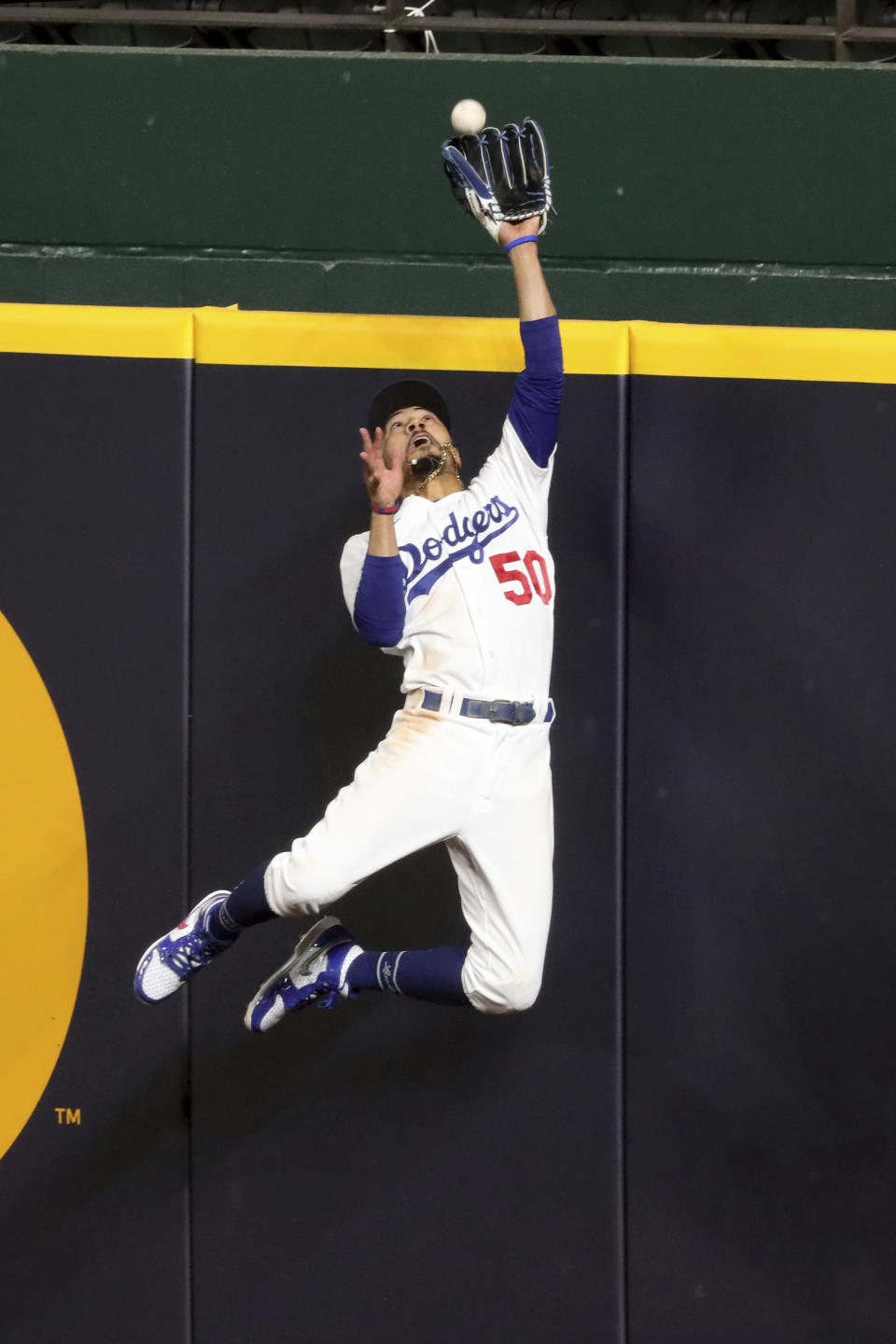 Los Angeles Dodgers right fielder Mookie Betts makes a catch and robs a home run from Atlanta Braves' Freddie Freeman during the fifth inning in Game 7 of a baseball National League Championship Series, Sunday, Oct. 18, 2020, in Arlington, Texas. (Curtis Compton/Atlanta Journal-Constitution via AP)