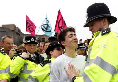 A police officer approaches a climate change activist at Waterloo Bridge during the Extinction Rebellion protest in London, Britain April 16, 2019. REUTERS/Peter Nicholls