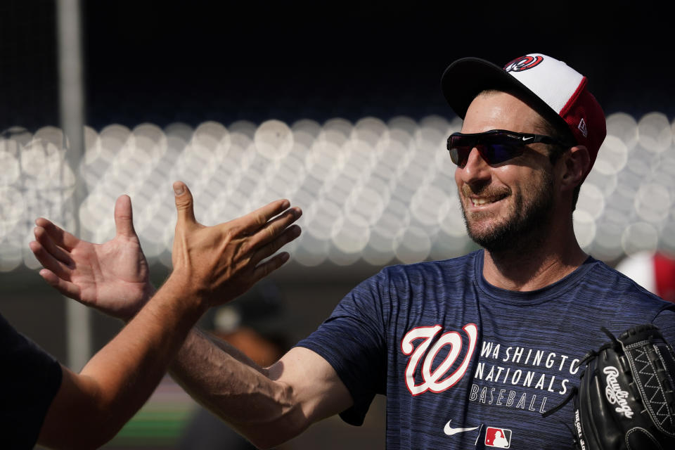 Washington Nationals pitcher Max Scherzer, right, greets Pittsburgh Pirates bench coach Don Kelly on the field before a baseball game, Monday, June 14, 2021, in Washington. (AP Photo/Carolyn Kaster)