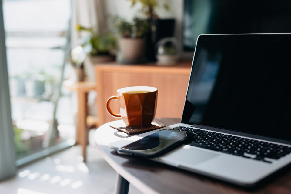 Cup of tea beside laptop and phone