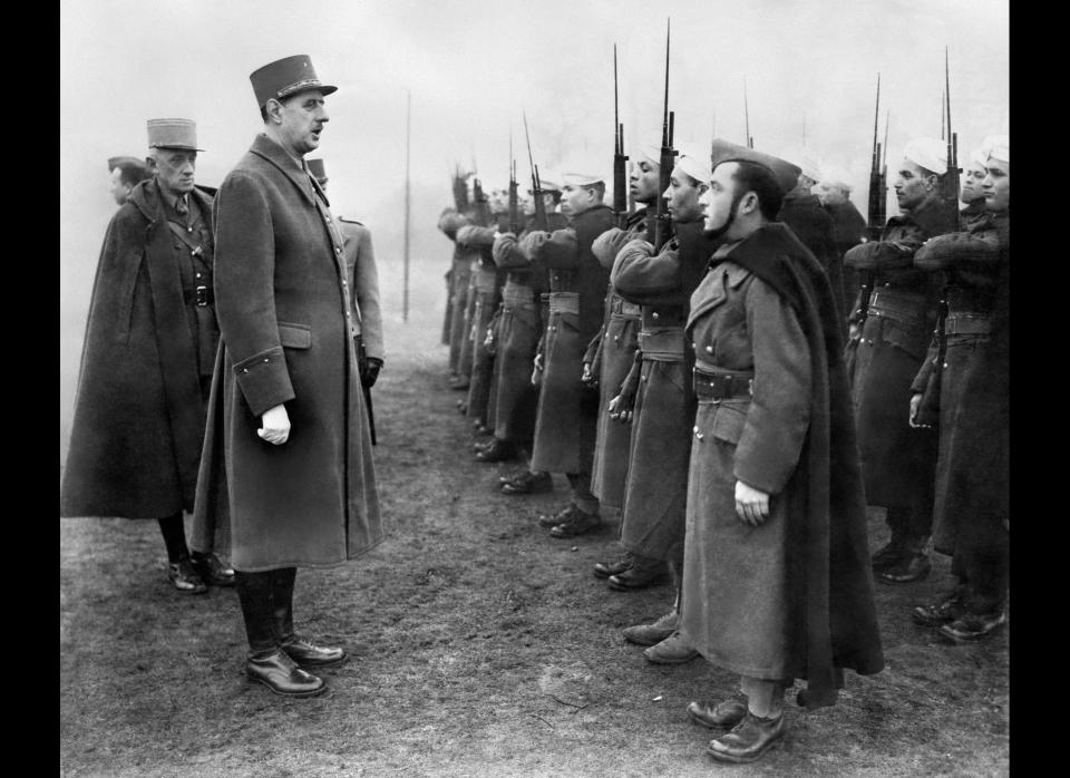 <p>Charles de Gaulle (C), Chief of the French Free Forces, inspects the French colonial troops during his visit of a military base in Great Britain on January 24, 1941 during World War II.&nbsp;</p>