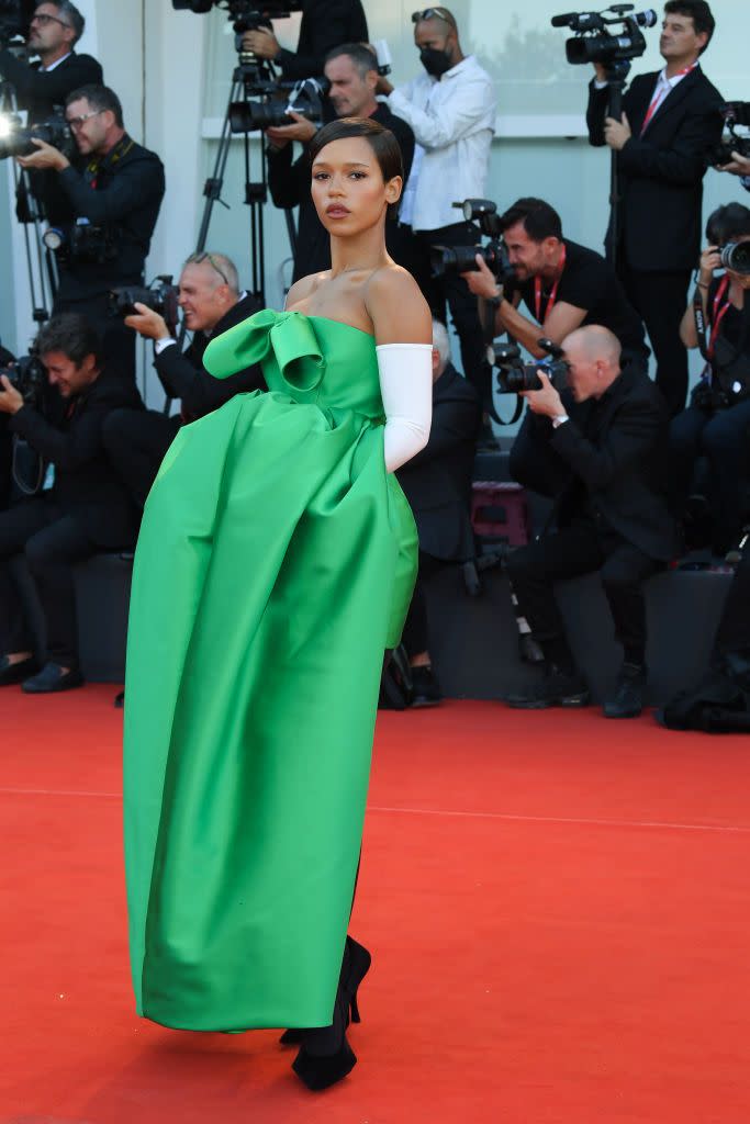 <p>Taylor Russell is wearing a customised Look 54 from the Balenciaga 51st Couture collection. She is wearing a Bustier Bell Dress in green technical silk twill with Opera gloves in white viscose and Space pumps in velvet-flocked rubber.</p>