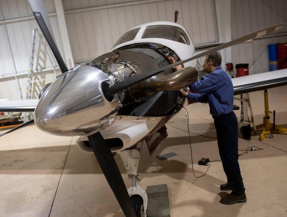 Chris Hopkins, Portage Flight Center aircraft mechanic and service provider, looks into an aircraft at the Portage County Regional Airport.