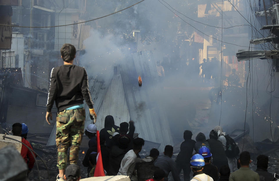 Riot police fire tear gas during clashes with anti-government demonstrators in Baghdad, Iraq, Saturday, Nov. 30, 2019. (AP Photo/Hadi Mizban)