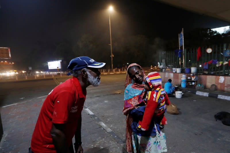 Mohammad Islam, who lives under a flyover, plays with his grand-daughter on a smoggy evening in New Delhi