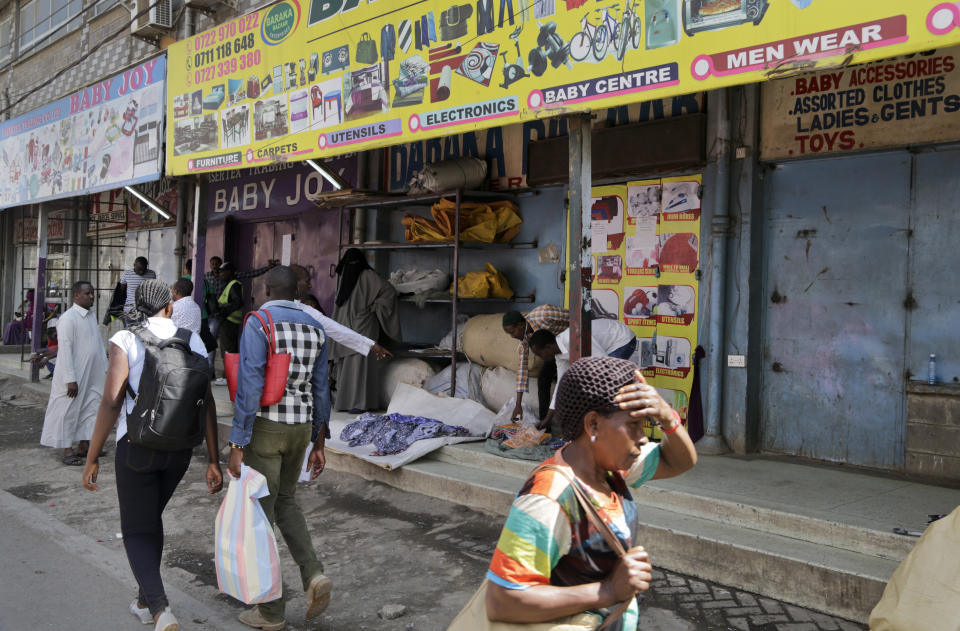 Kenyans walk past closed shops in the Eastleigh area of the capital, after members of the business community there closed the shops as a protest to condemn Tuesday's attack on a hotel complex, in Nairobi, Kenya Friday, Jan. 18, 2019. Extremists stormed a luxury hotel complex in Kenya's capital on Tuesday, setting off thunderous explosions and gunning down people at cafe tables in an attack claimed by militant group al-Shabab. (AP Photo/Khalil Senosi)