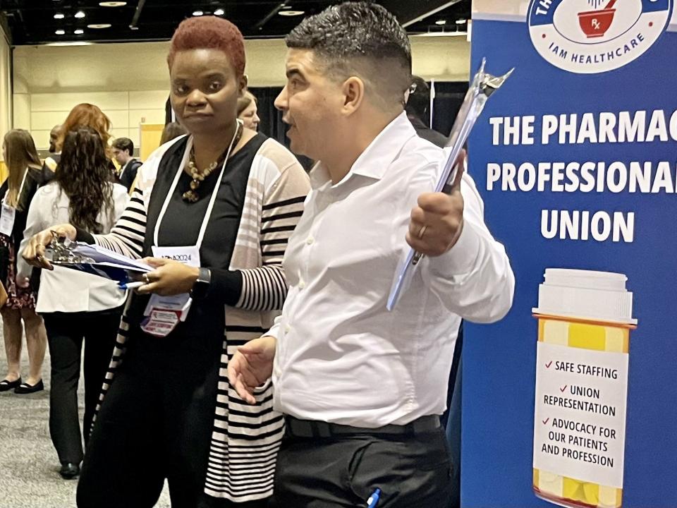 Bled Tanoe (left) and Shane Jerominski, founding members of a new national union for pharmacy workers, The Pharmacy Guild, talk to pharmacists at the American Pharmacists Association's annual conference in Orlando, Florida, on Sunday, March 24, 2024.