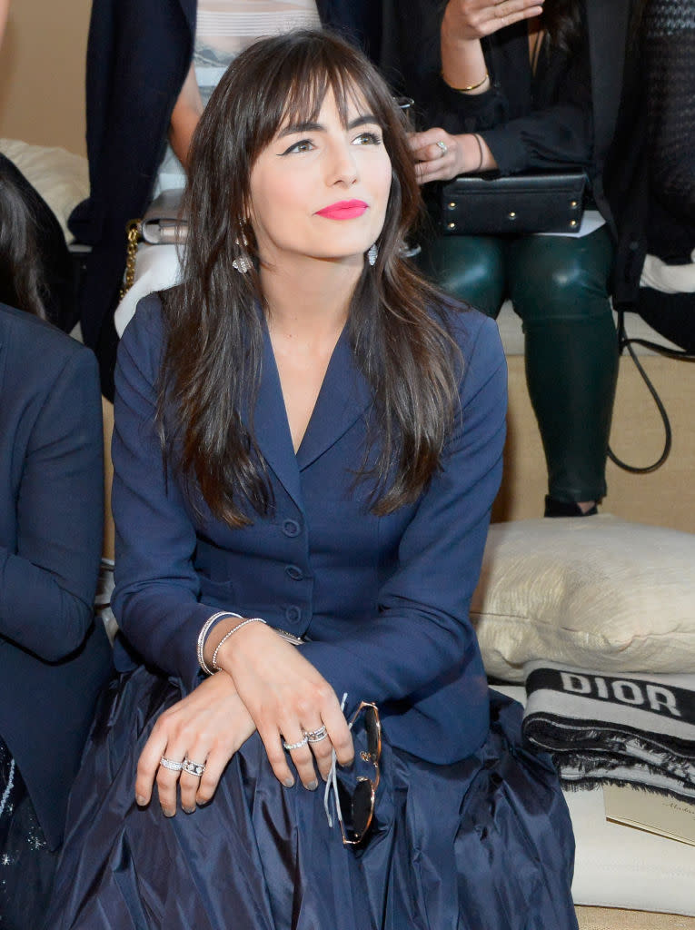 <p>Belle’s face-framing bangs and long layers add a touch of sophistication to her navy ensemble, while her bright coral lipstick is fresh and youthful. (Photo: Stefanie Keenan/Getty Images for Christian Dior) </p>