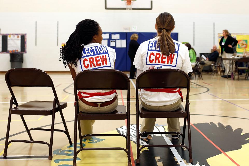 Kaylee Taylor (left) and Amber Taylor (no relation), both 17 and of Dublin, Ohio, wait to assist voters voting at the Wyandot Elementary School in Dublin, Ohio on Tuesday, November 6, 2012. Both girls were working for Youth at the Booth, a program that allows high school seniors to work at polling stations and gives them an opportunity to be involved in the polling process.