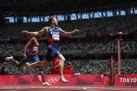 <p>Norway's Karsten Warholm crosses the finish line to win break the world record in the men's 400m hurdles final during the Tokyo 2020 Olympic Games at the Olympic Stadium in Tokyo on August 3, 2021. (Photo by Jewel SAMAD / AFP)</p> 